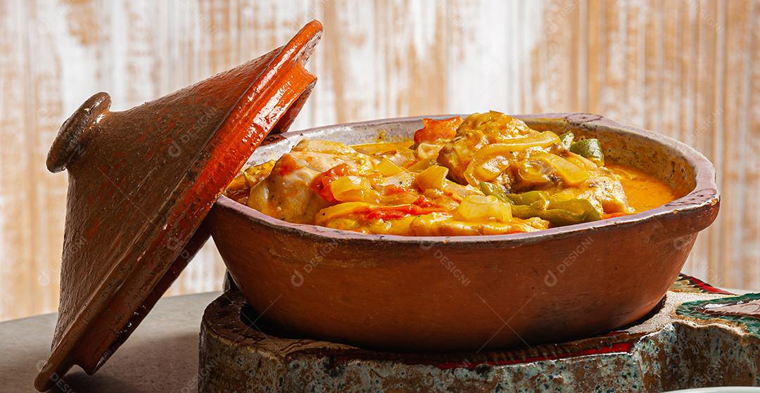 Moqueca de garoutureira servida com arroz de açafrão, farofa e pirão e molho de pimenta. Comida típica brasileira.