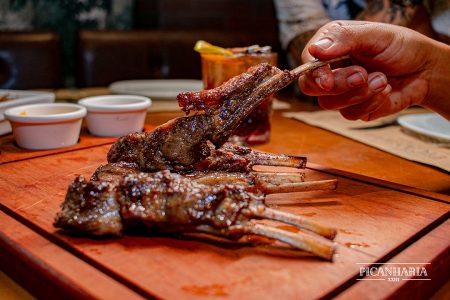 Churrasco costela curta fatiada em tabua madeira com gordurinha.