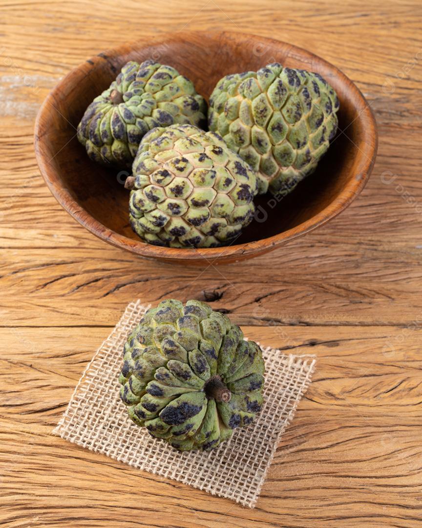 Maçãs de açúcar ou maçãs de creme em uma tigela sobre a mesa de madeira