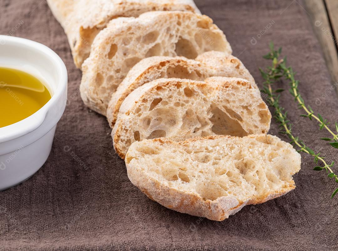 Tradicional pão de ciabatta caseiro com fatias e azeite