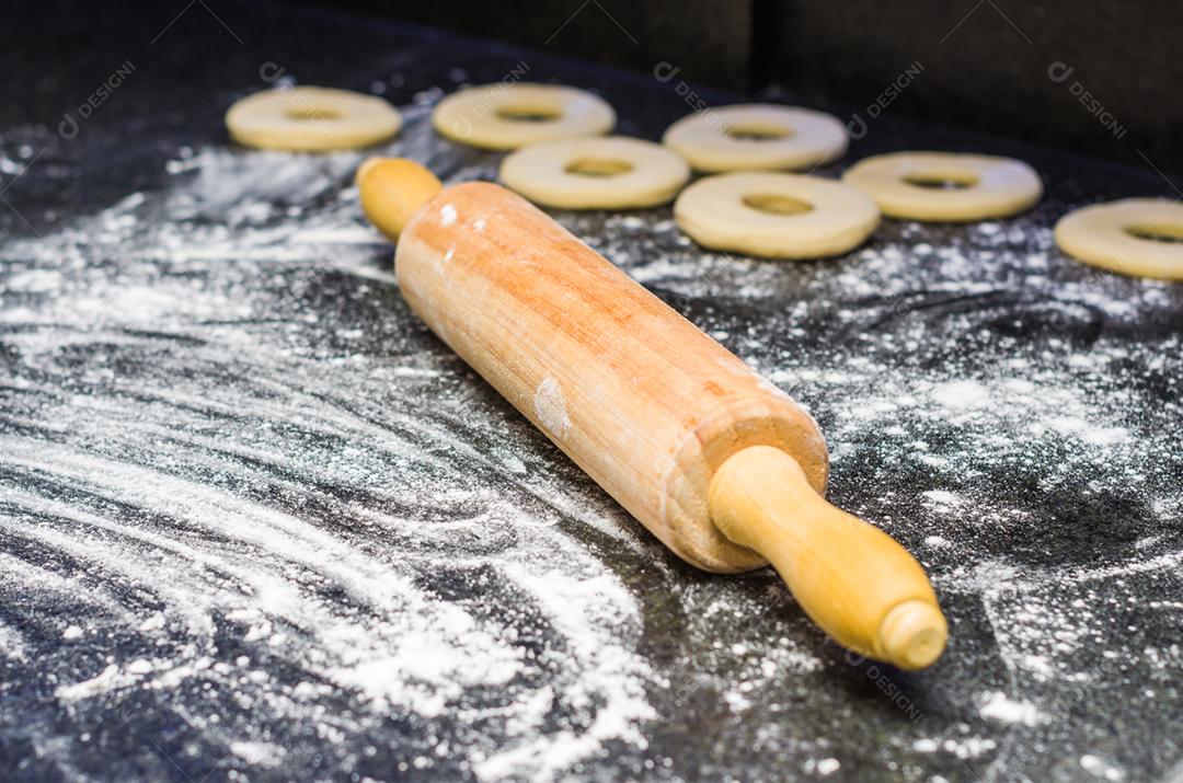 Preparando rosquinhas com rolo de macarrão em pedra.