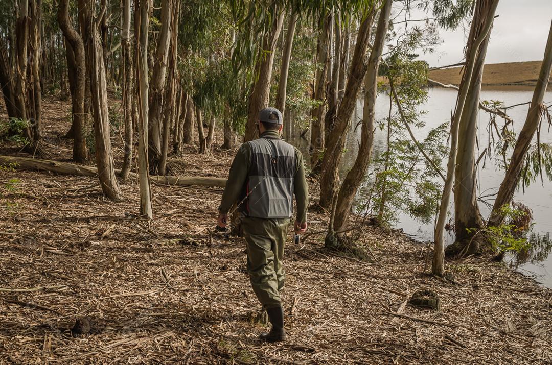 Pescador esportivo de pesca no lago em dia nublado