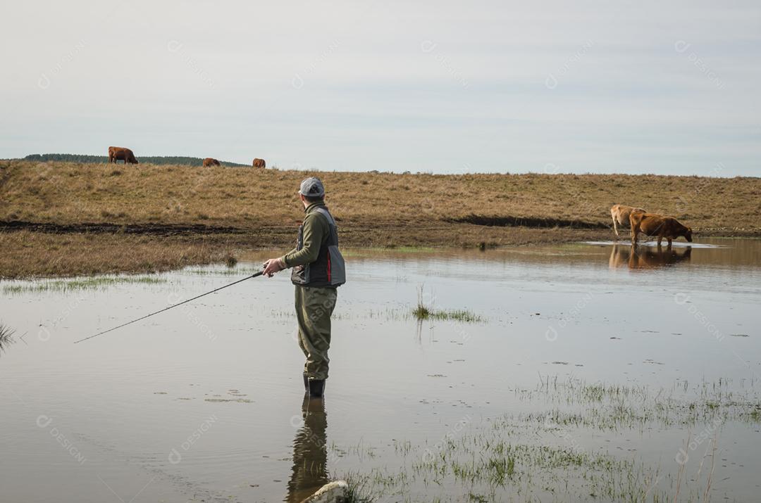 Pescador esportivo de pesca no lago em dia nublado
