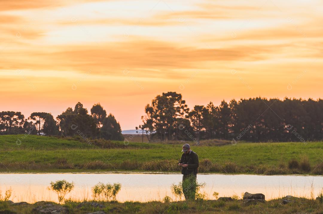 Pescador esportivo de pesca no lago em dia nublado