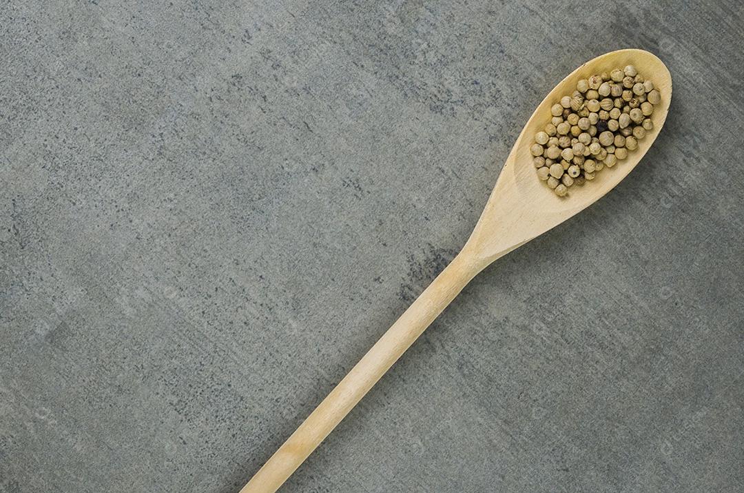 Especiaria de pimenta branca em colher de pau