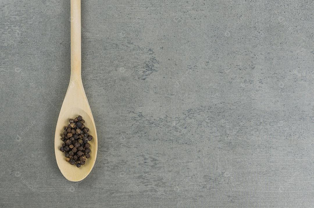 Especiaria de pimenta preta em colher de pau