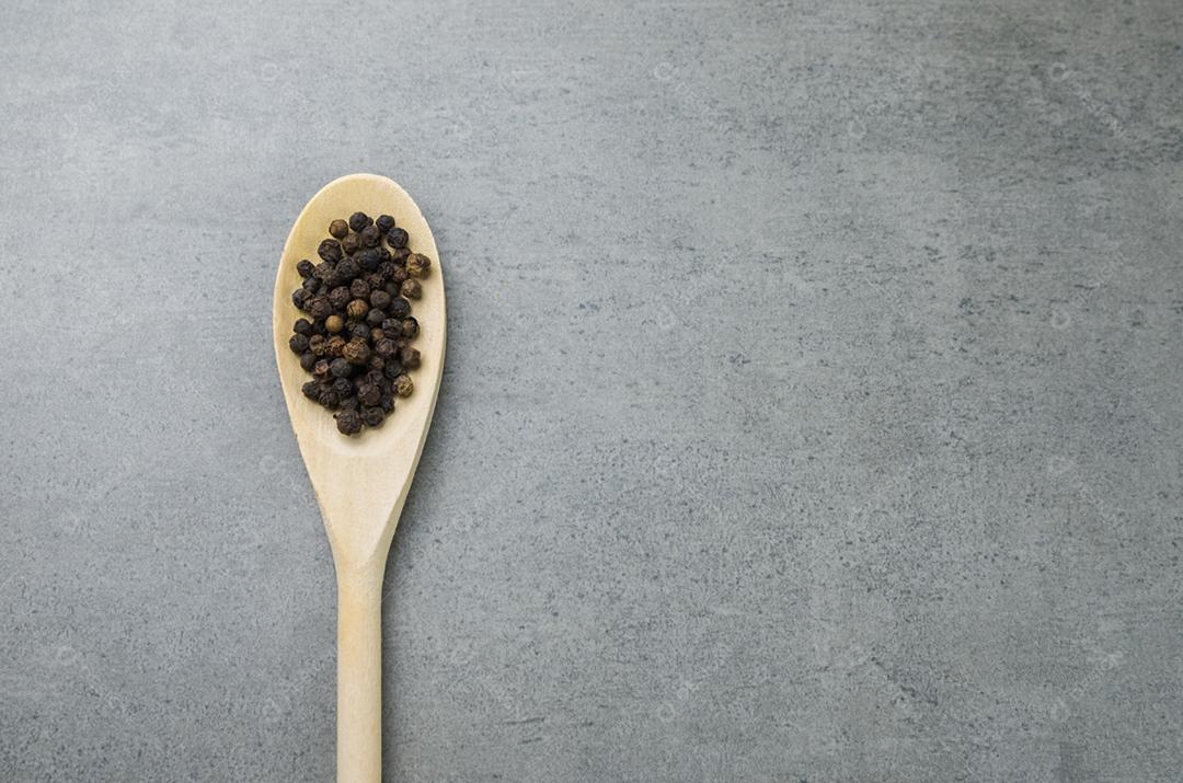 Especiaria de pimenta preta em colher de pau