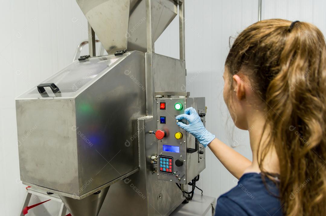 Mulher que trabalha na indústria, ajustando o termostato do tanque