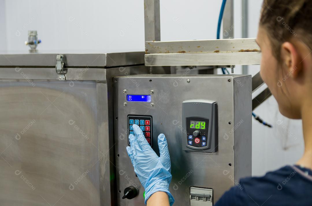 Woman working in industry, adjusting the thermostat on the tank