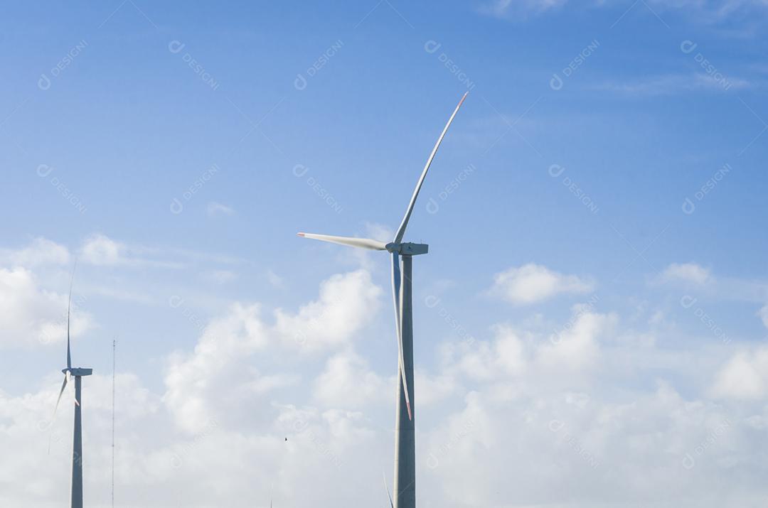 Moinhos de vento durante o dia de verão brilhante com céu azul, conceito de energia limpa e renovável.