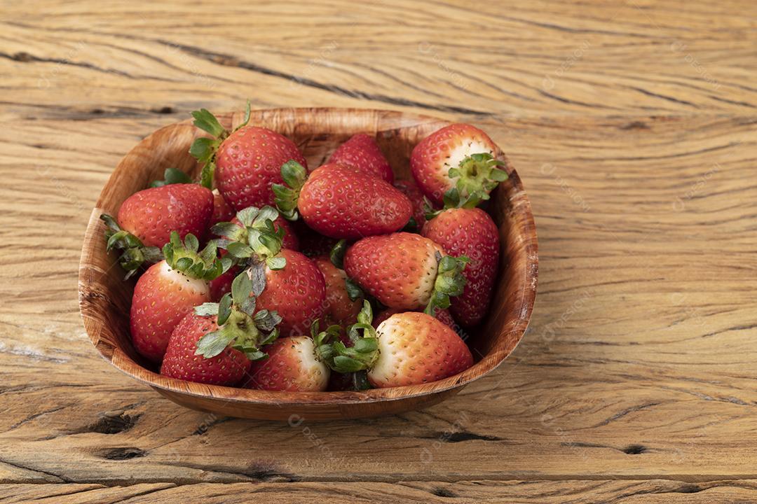 Morangos em uma tigela sobre mesa de madeira