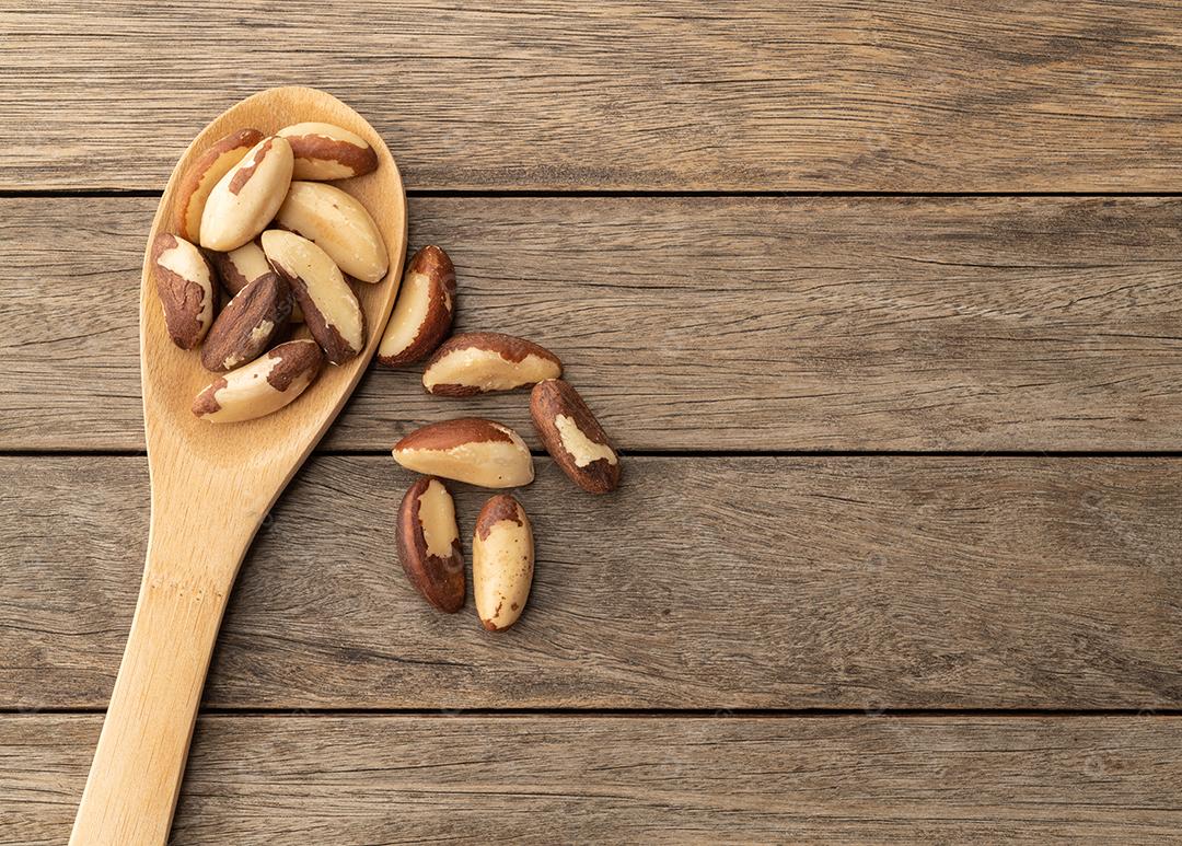 Castanha-do-pará em uma colher sobre mesa de madeira