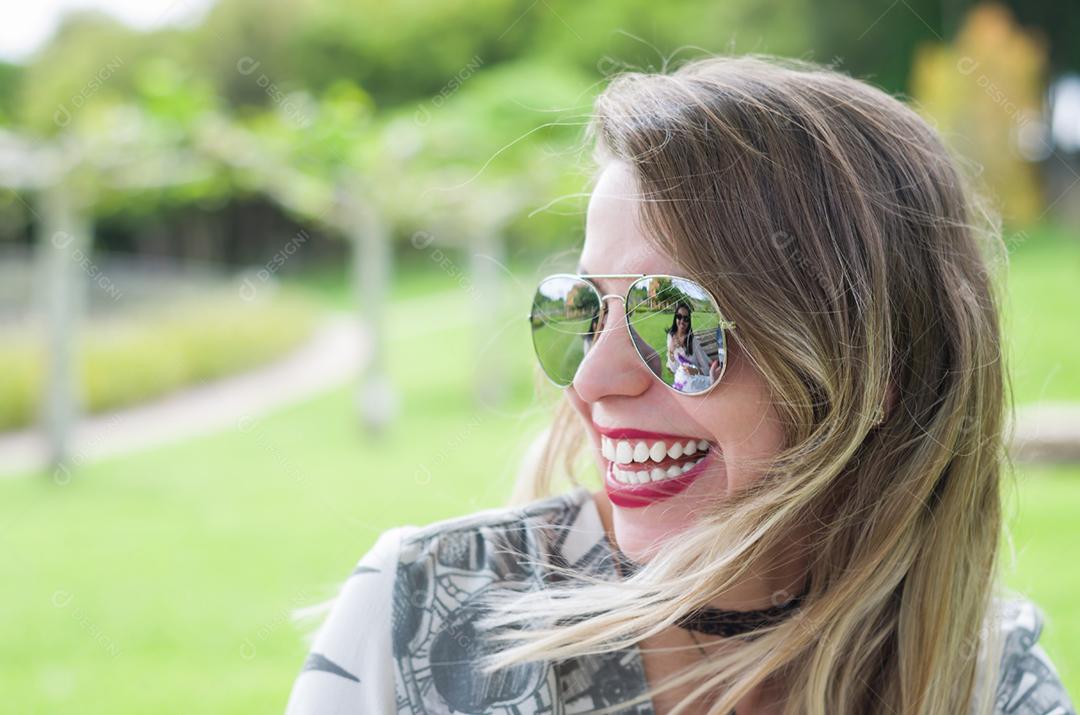 Young happy blonde woman laughing on the lawn.