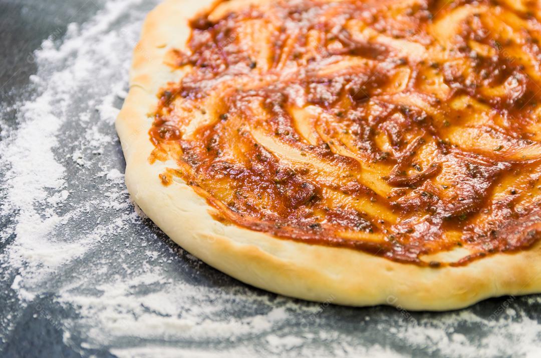 Preparando pizza, close-up de massa de pizza com molho de tomate.