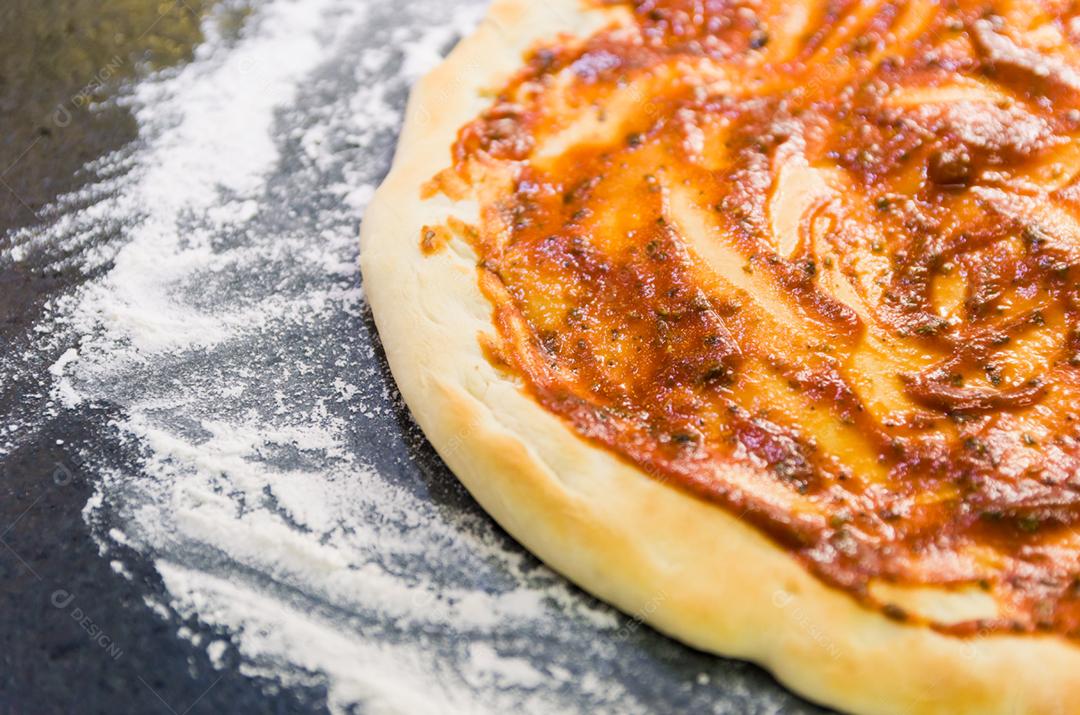 Preparando pizza, close-up de massa de pizza com molho de tomate.