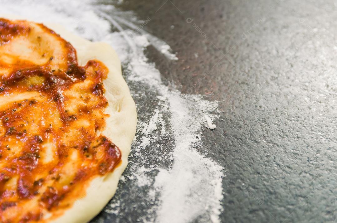 Preparando pizza, close-up de massa de pizza com molho de tomate.