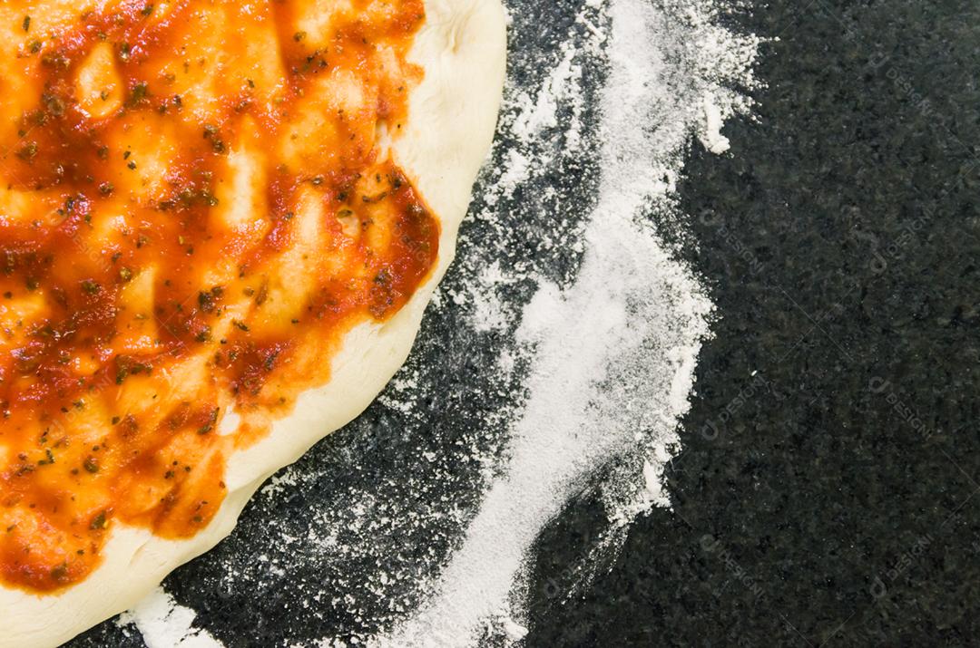 Preparando pizza, close-up de massa de pizza com molho de tomate.