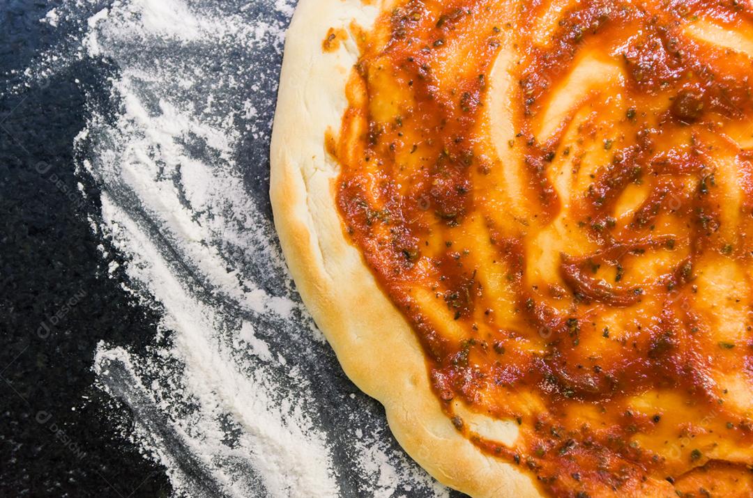Preparando pizza, close-up de massa de pizza com molho de tomate.