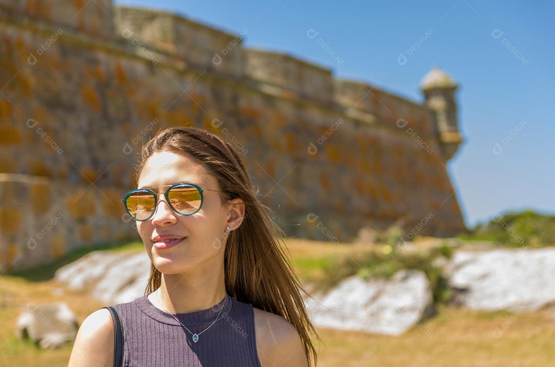 Turista feminina visitando o Forte de Santa Tereza no Uruguai, um importante ponto turístico.