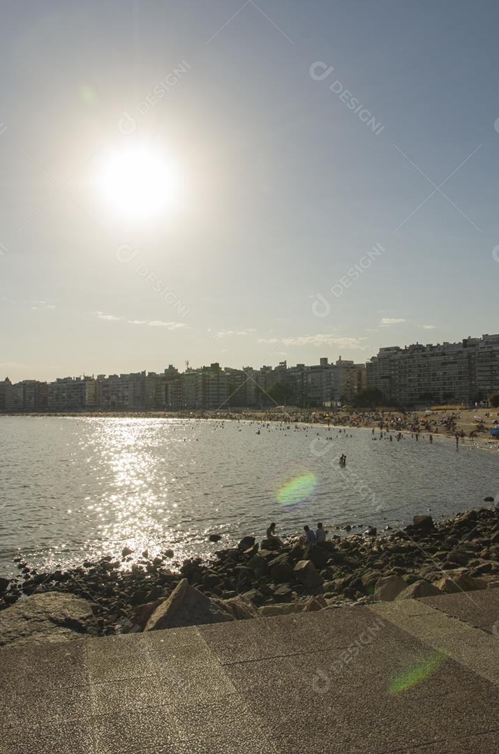 Belo pôr do sol na praia de Pocitos com banhistas em um dia de verão em Montevidéu Uruguai.