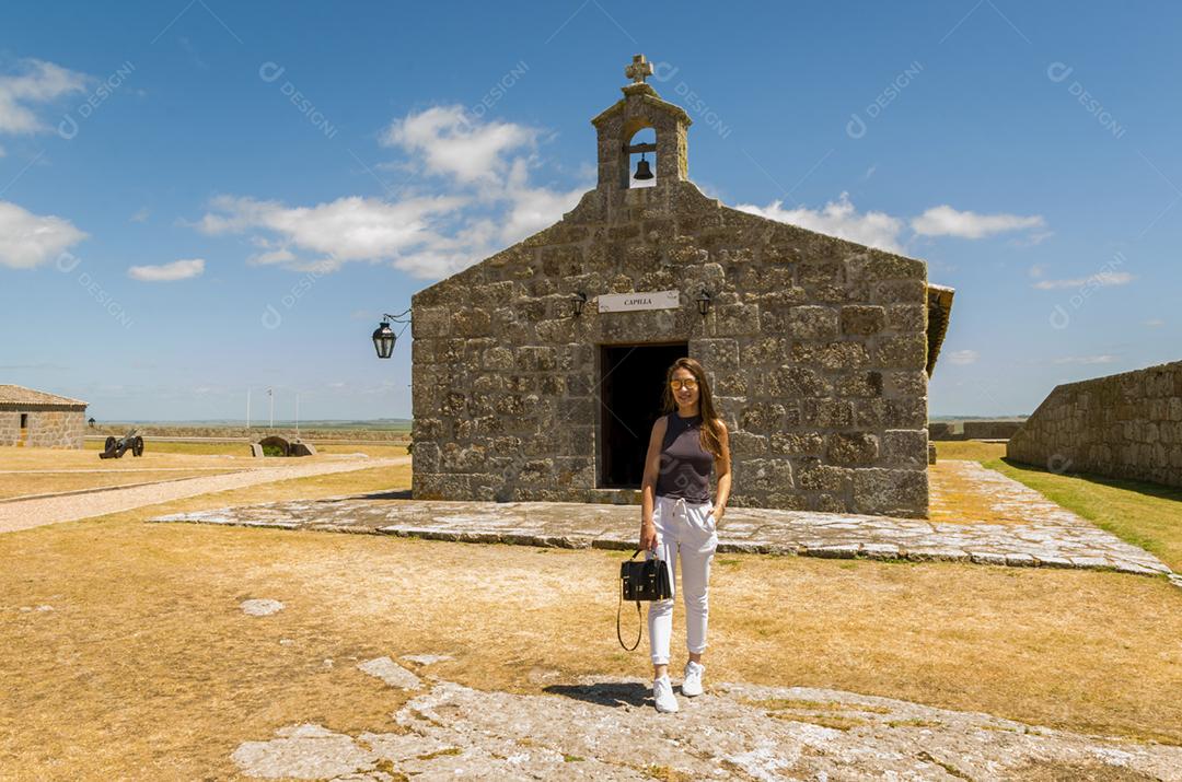 Turista feminina visitando o Forte de Santa Tereza no Uruguai, um importante ponto turístico.