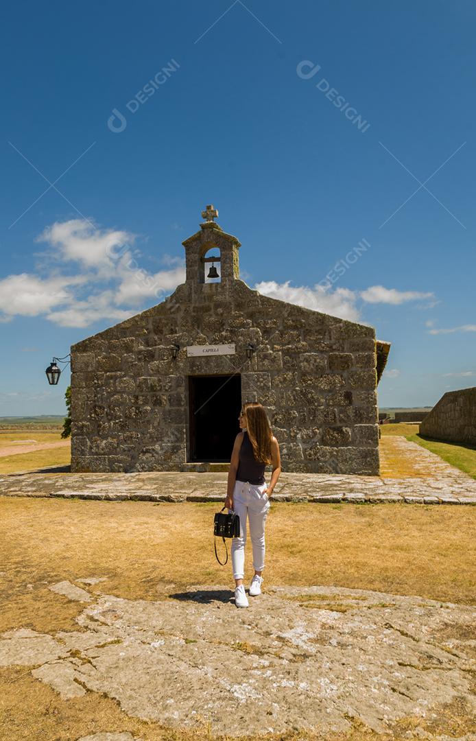 Turista feminina visitando o Forte de Santa Tereza no Uruguai, um importante ponto turístico.