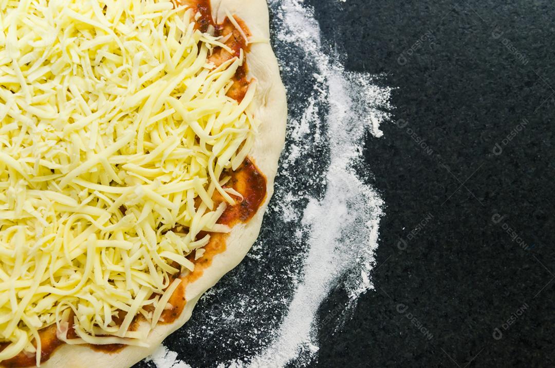 Preparando pizza, close-up de massa de pizza com molho de tomate e queijo mussarela.