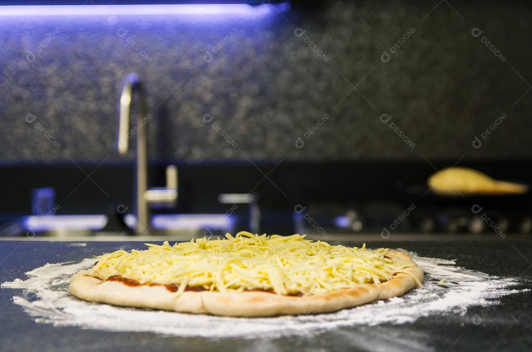 Preparando pizza, close-up de massa de pizza com molho de tomate e queijo mussarela.