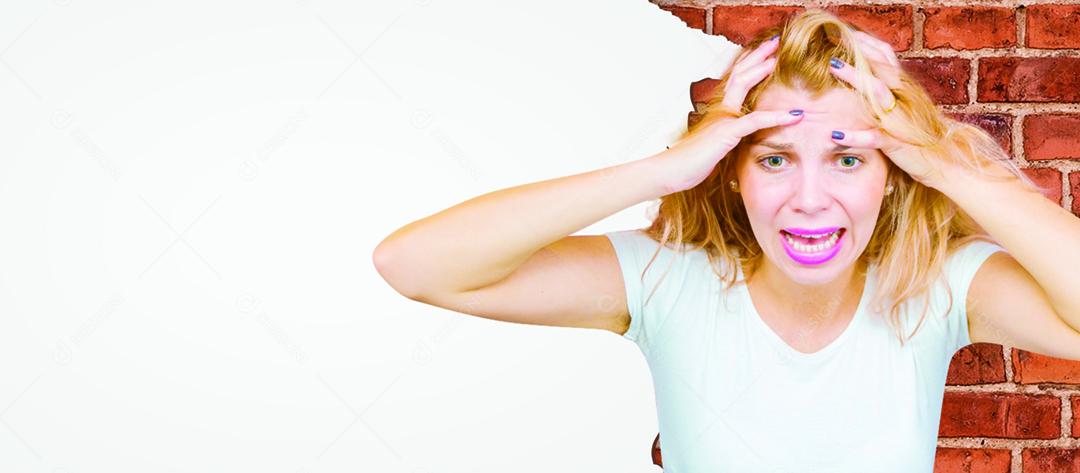 Mulher loira com maos na cabeça com expressão de desesperada