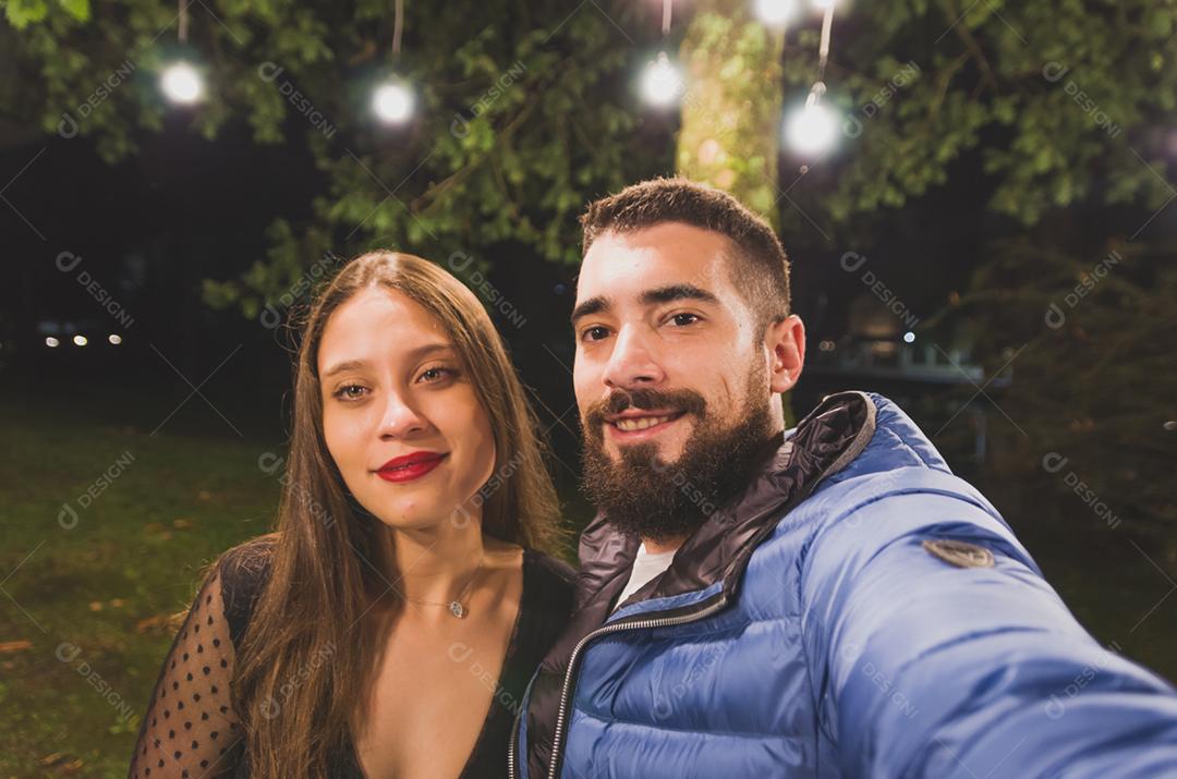 Jovem casal tirando uma selfie sobre praça