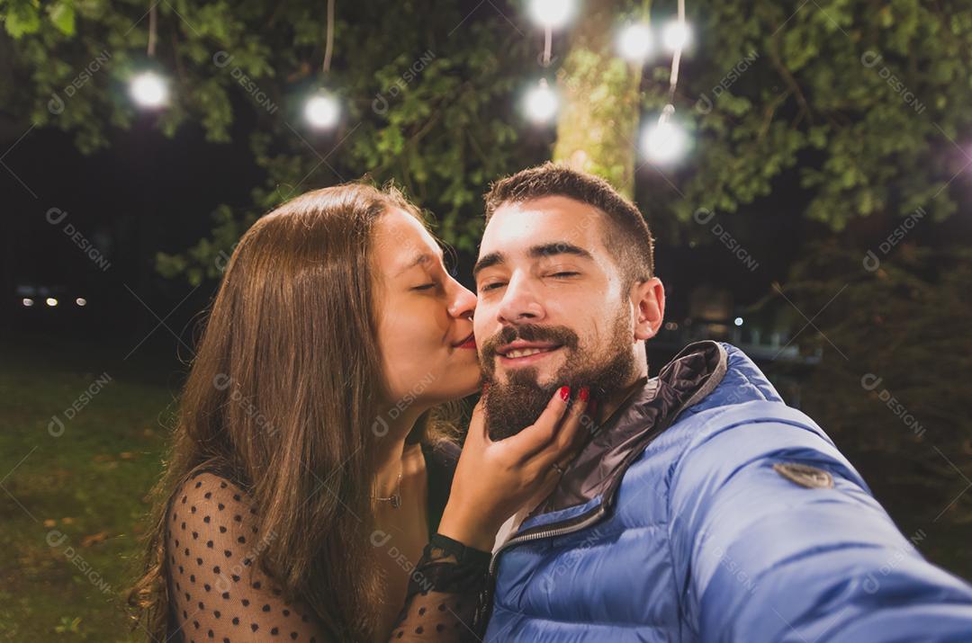 Jovem casal tirando uma selfie sobre praça