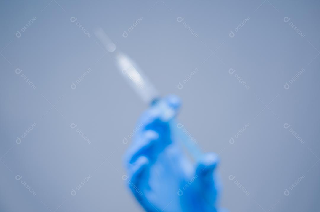 Grande conceito de medicina, foto borrada para fundos, seringa de injeção de mão segurando.