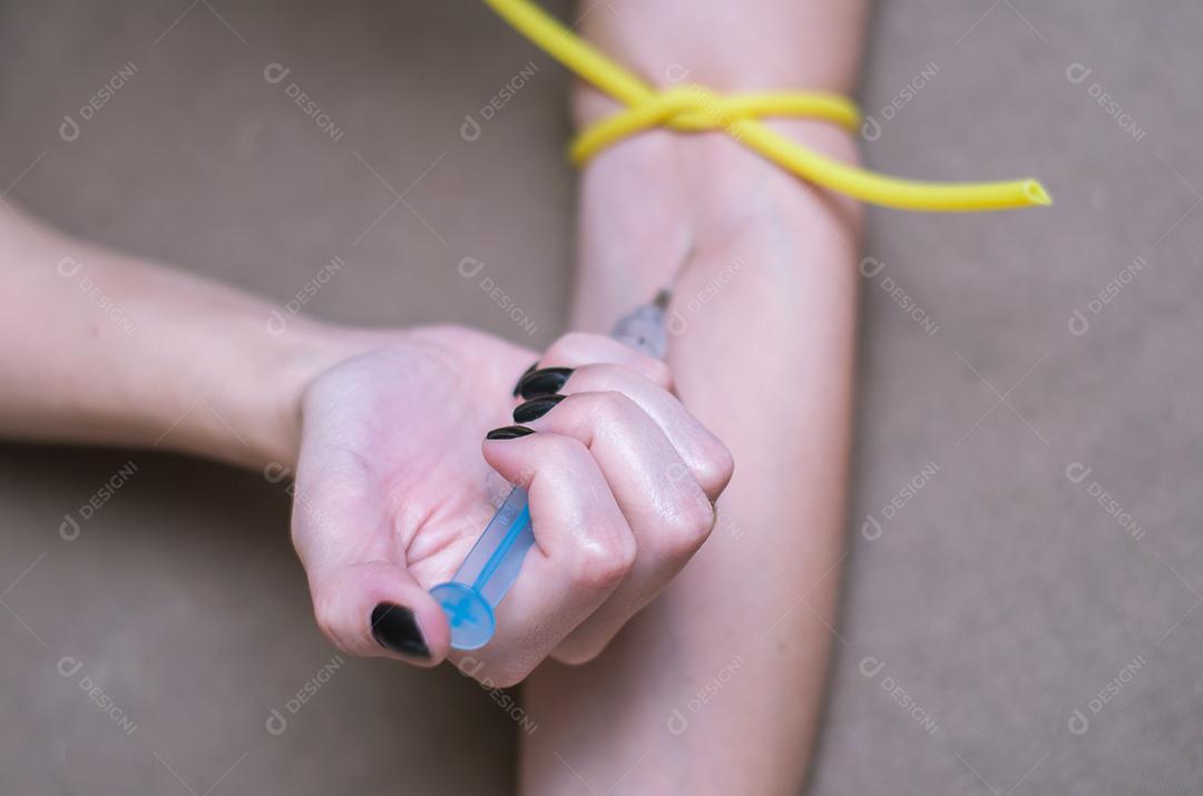 Grande conceito de drogas, jovem aplicando seringa no braço.