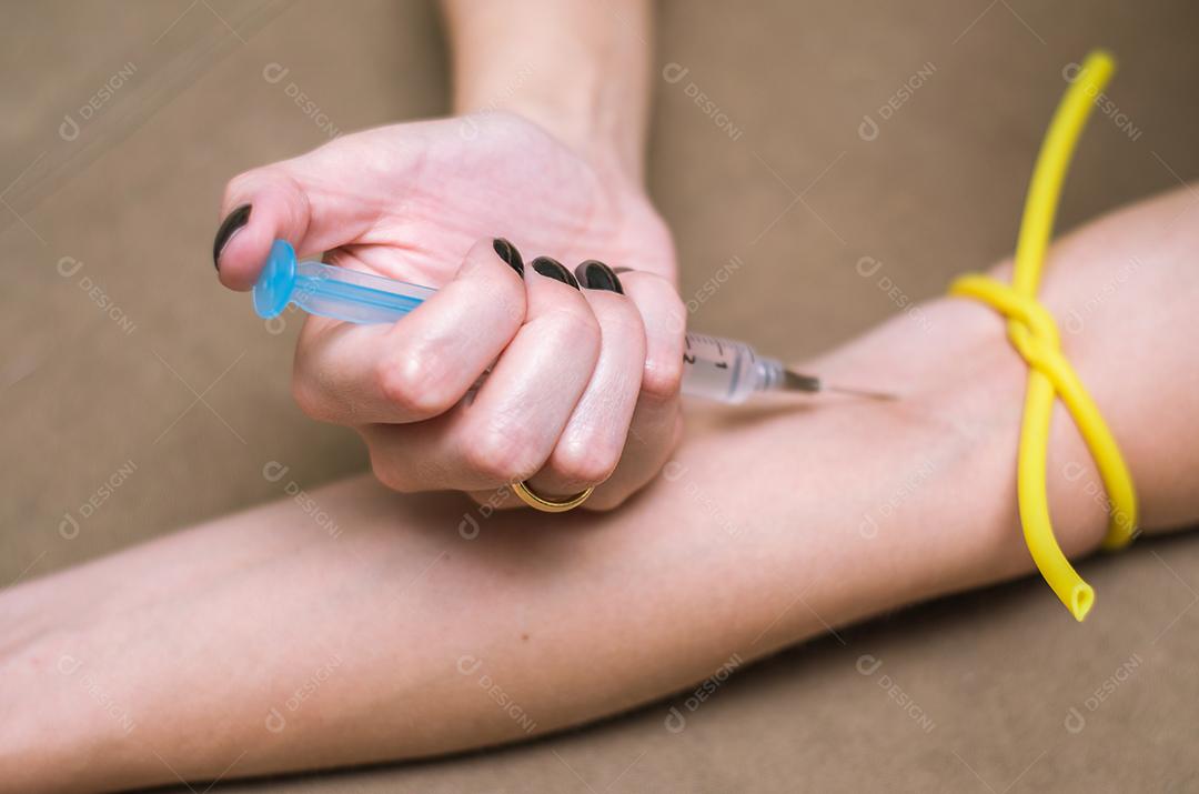 Grande conceito de drogas, jovem aplicando seringa no braço.