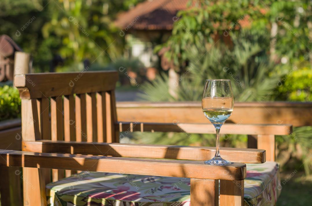 Cadeira sobre uma varando taça de vidro com água dentro