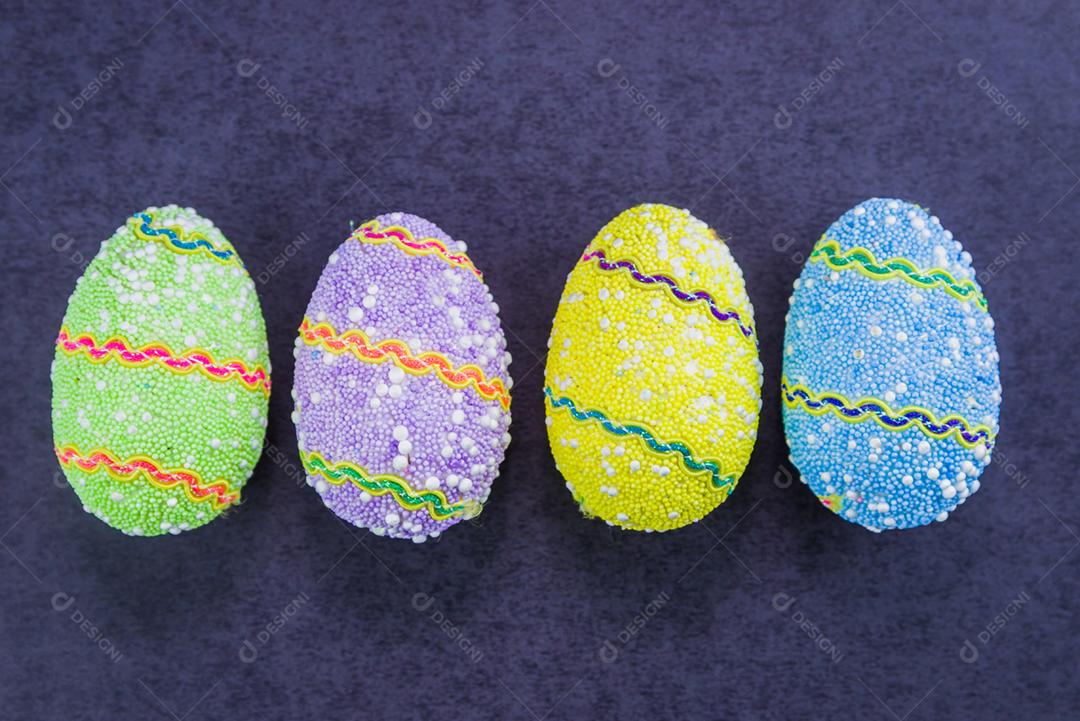 Ovos de Páscoa coloridos em um fundo preto na moda.