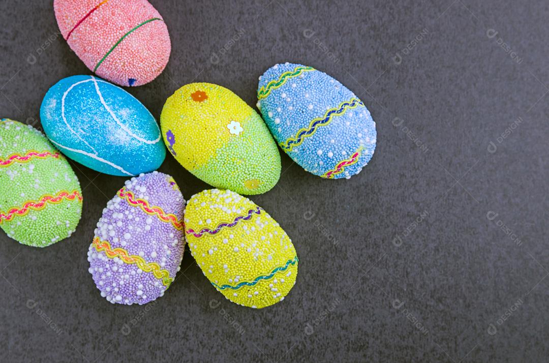 Ovos de Páscoa coloridos em um fundo preto na moda.