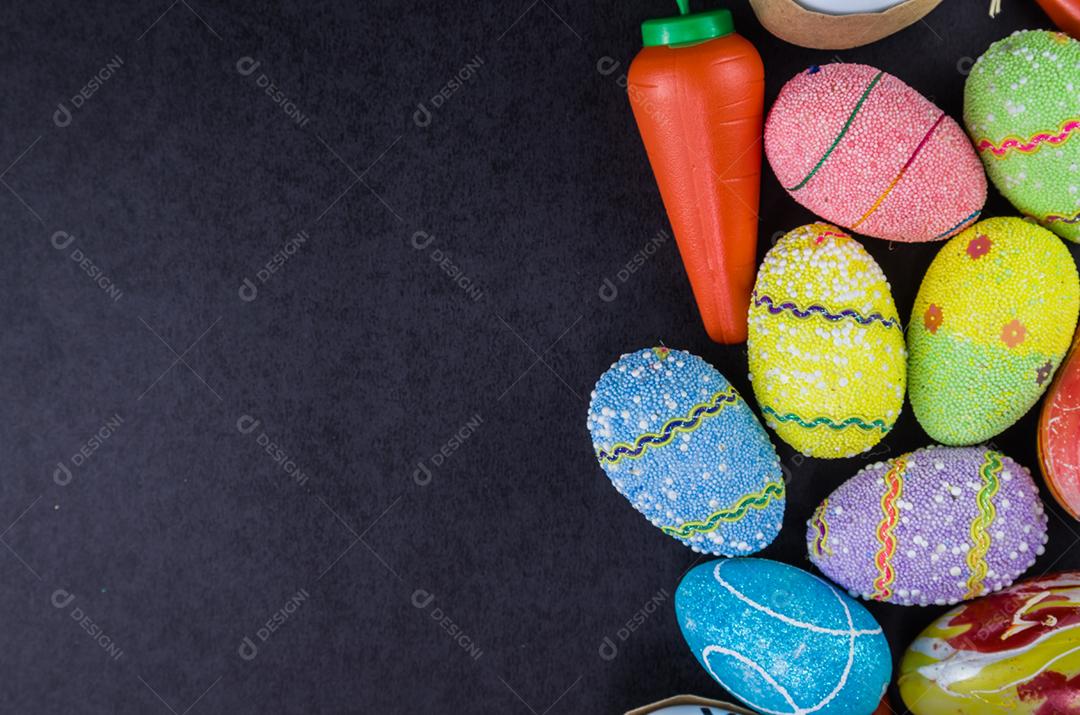Colorful easter eggs and other objects on a modern black background for various easter themed backgrounds