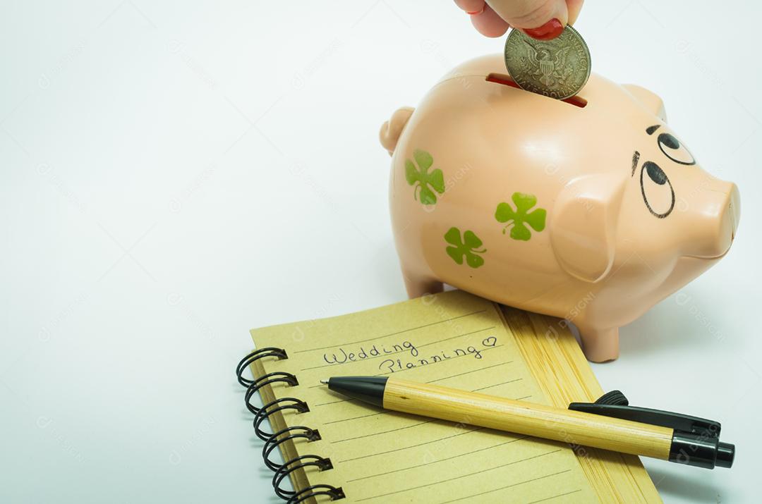 Grande conceito de economia para férias, cofrinho, caderno e caneta.