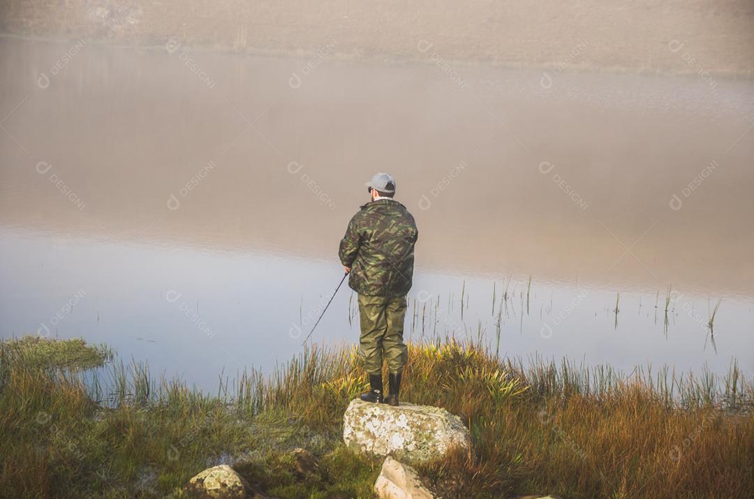 Pescador esportivo de pesca no lago em dia nublado