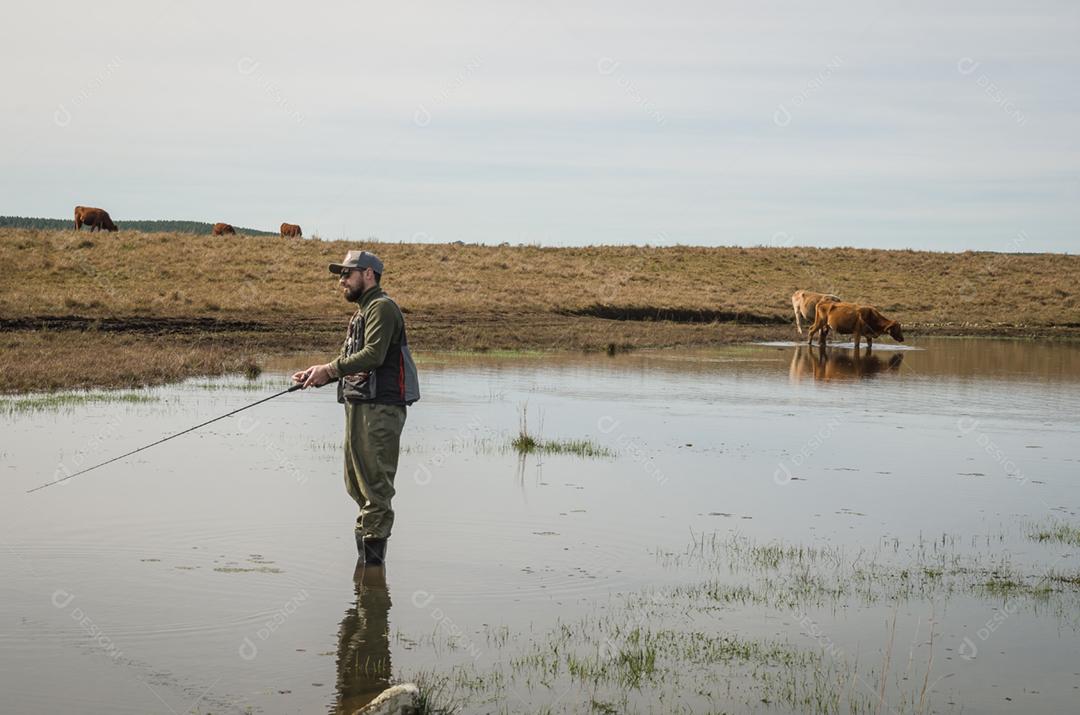 Pescador esportivo de pesca no lago em dia nublado