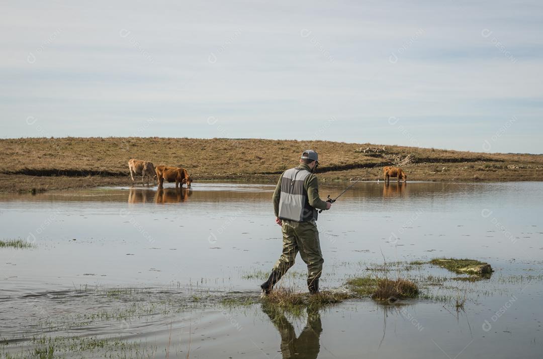 Pescador esportivo de pesca no lago em dia nublado