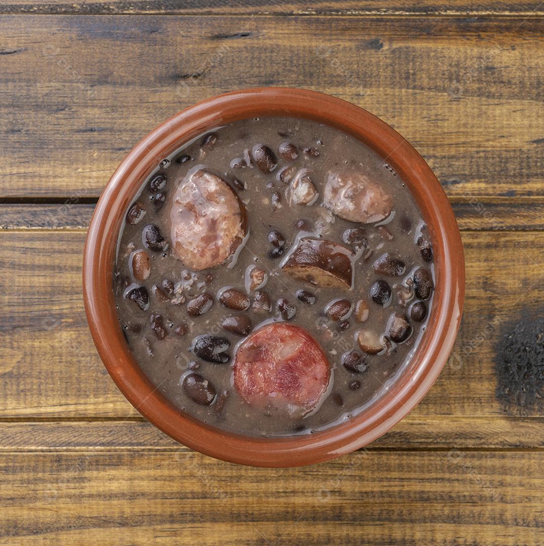 Tradicional feijoada brasileira em uma tigela sobre mesa de madeira