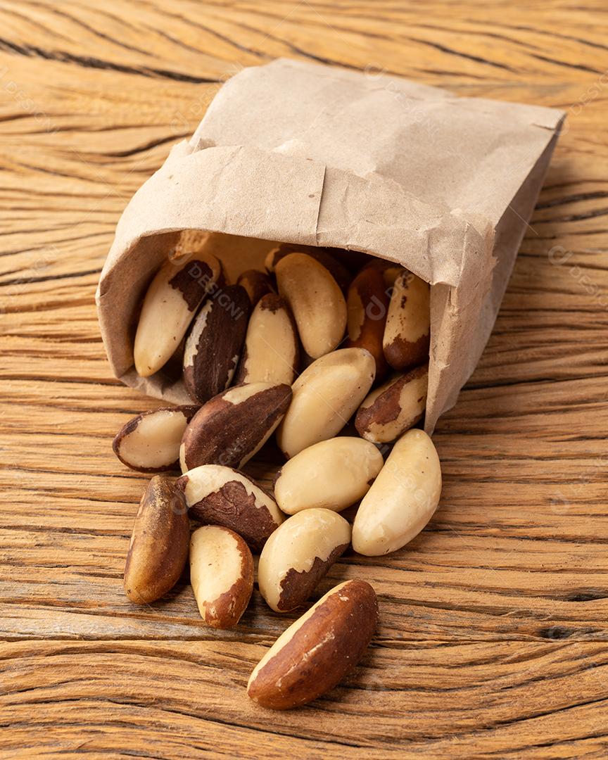 Castanha-do-pará em um saco de papel sobre mesa de madeira