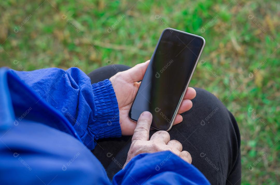 Dedo enrugado de um mulher, tocando em um telefone celular