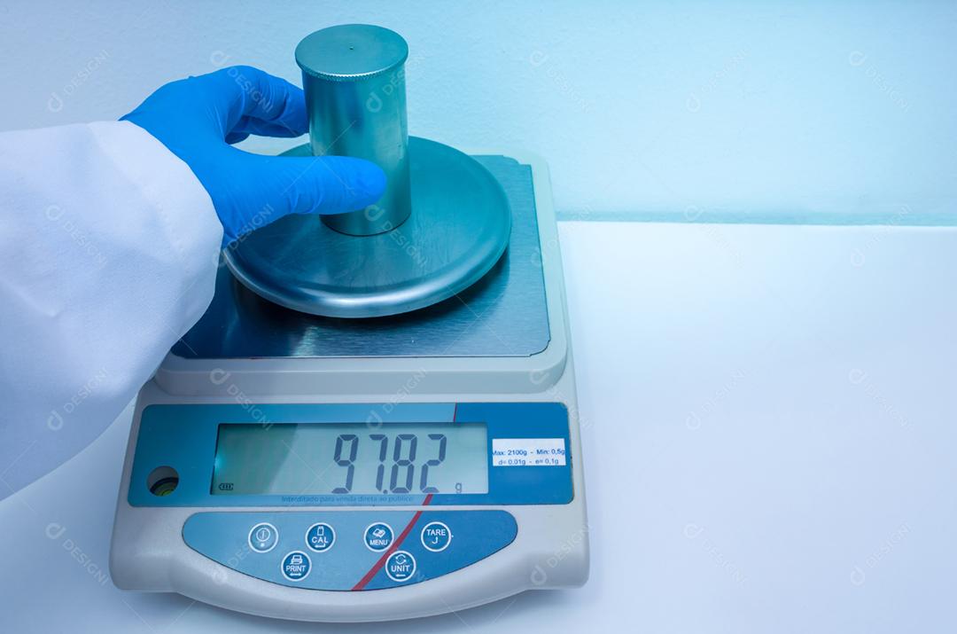 Grande conceito de pesquisa e desenvolvimento, medindo manualmente a densidade de um líquido com o picnômetro.