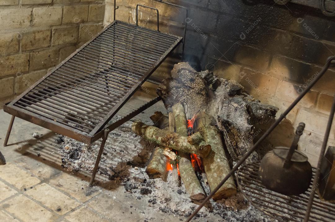 Lenha sendo queimados brasa fogo fumaça sobre galpão