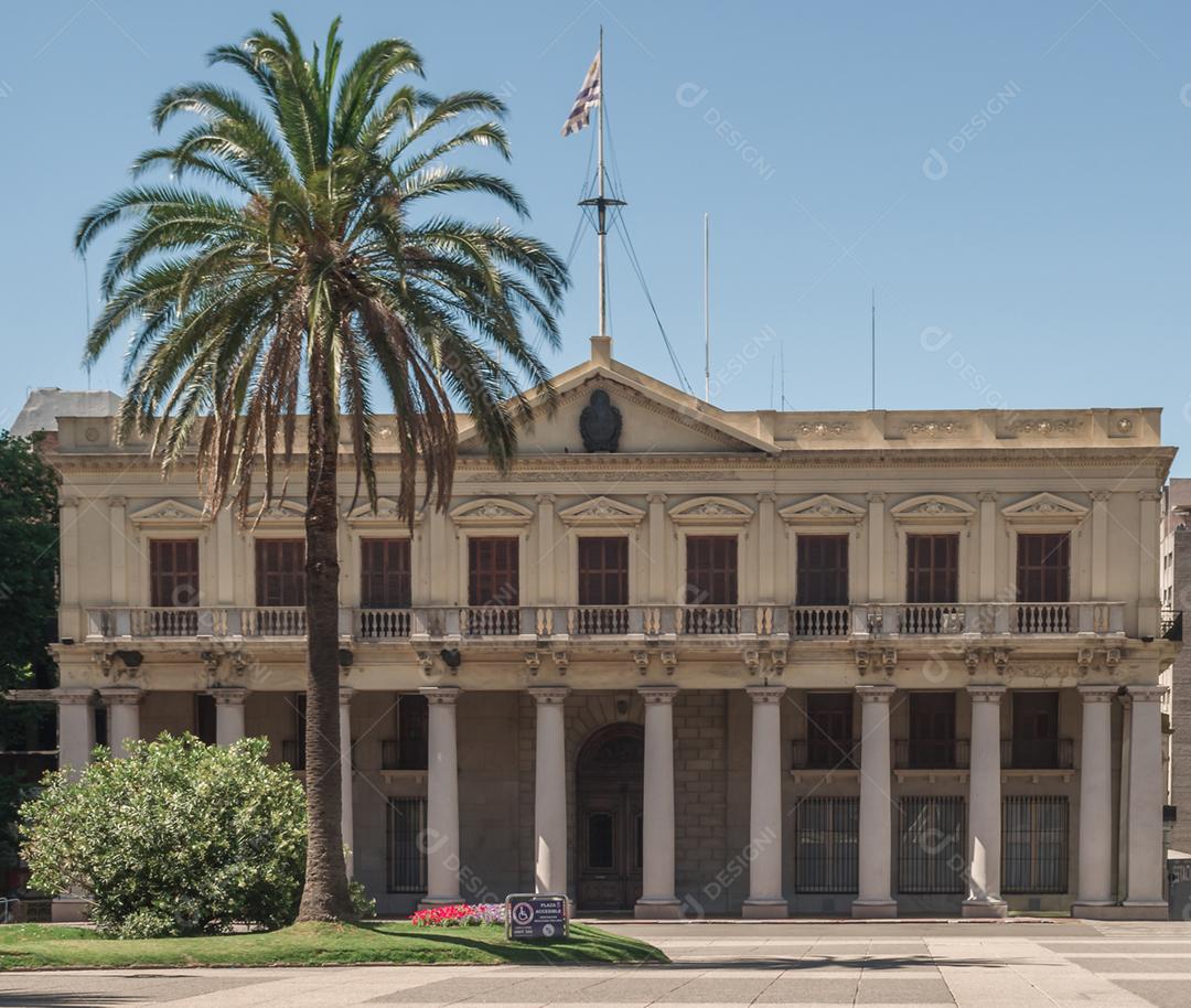 Fachada de um prédio arvores coqueiros céu azul
