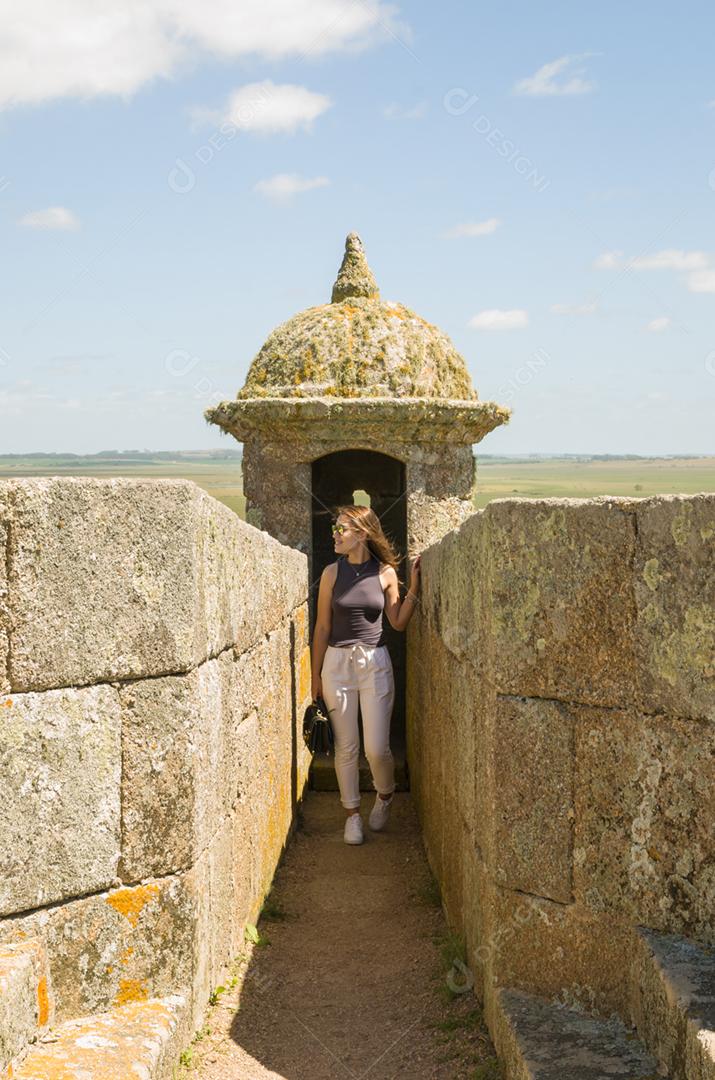 Jovem olhando Forte de Santa Tereza no Uruguai, importante local turístico.