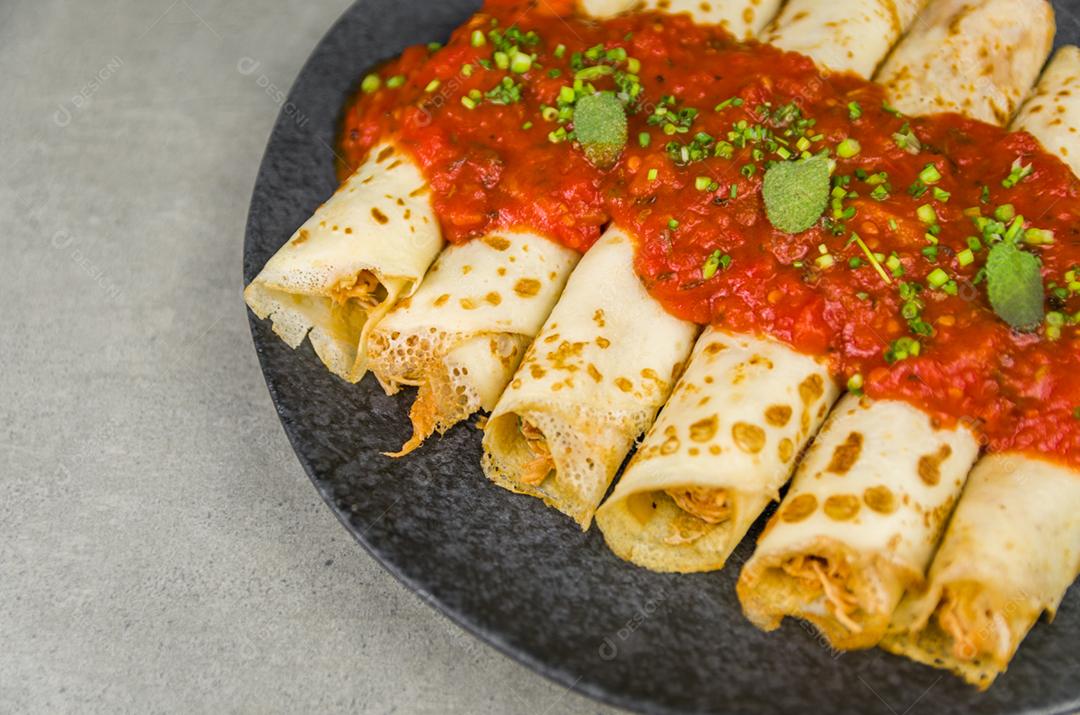 Panquecas brasileiras com frango, molho de tomate à bolonhesa, panquecas enroladas.